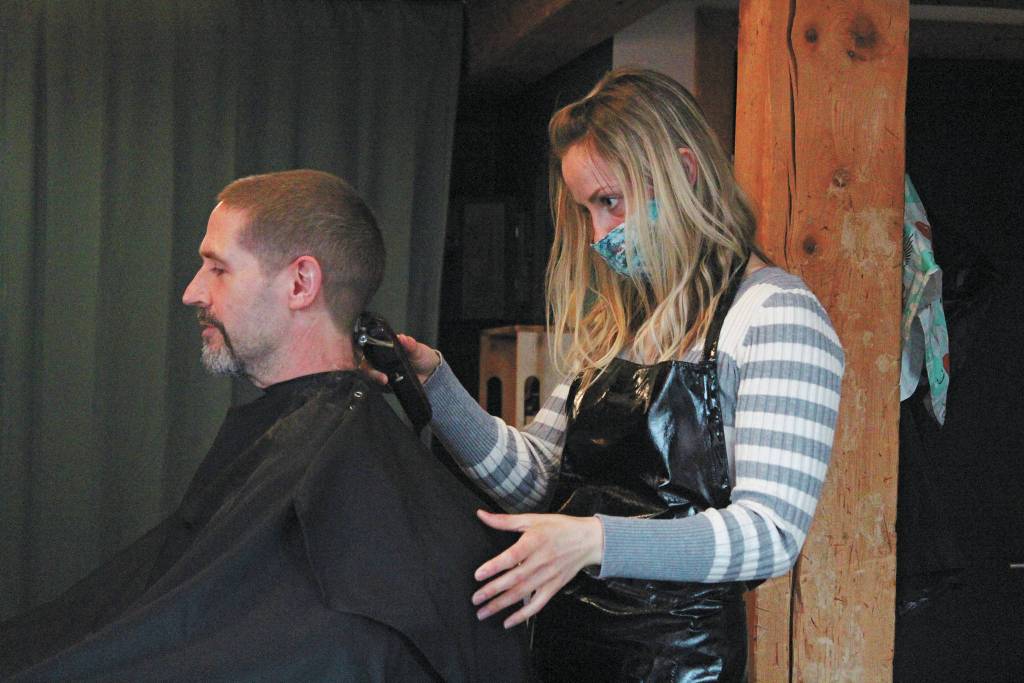 Ashley Story gives a haircut to client Michael Halstead on Friday, April 24, 2020 at her salon Short Cuts on Lake Street in Homer, Alaska. Storys is one of several Homer businesses to reopen their doors Friday according to relaxed state restrictions, while several others have opted to wait. (Photo by Megan Pacer/Homer News)