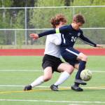 Homers Austin Shafford battles to control the ball while under pressure from Grace Christians Jackson Tanner during a May 24, 2019 game in the Division II state soccer championship tournament at Eagle River High School in Eagle River, Alaska. (Photo by Megan Pacer/Homer News)