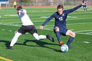 Homers Daniel Reutov snags the ball from a Kenai player during a soccer game on April 16, 2019 at Homer High School in Homer, Alaska. (Photo by Megan Pacer/Homer News)