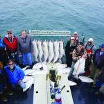 Anglers stand by a rack of halibut on the Irish as the North Country Charters boat returned to Homer, Alaska, in July 2017. Keeping people socially distant is one challenge charter captains face. (Photo by Michael Armstrong/Homer News file photo)