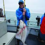 Øisten Stokke Berget of Trondheim, Norway, holds a halibut he caught while fishing on the North Country Charters fishing boat Irish on July 16, 2017, near Homer, Alaska. Because foreign and Lower 48 travelers to Alaska have to quarantine for 14 days under current mandates, charter operators dont expect to see many such clients this summer. (Photo by Michael Armstrong/Homer News file photo)