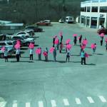 Health care workers hold up signs spelling out thank you while four F-22 Raptors fly over Homer at South Peninsula Hospital on Friday, May 15, 2020 in Homer, Alaska. (Photo by Lisa Talbott)