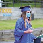Graduate Rylee Doughty walks back to her family and their vehicle after getting her diploma during Homer High Schools drive-through commencement ceremony Monday, May 18, 2020 at the school in Homer, Alaska. (Photo by Megan Pacer/Homer News)