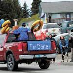 Graduate Isaiah Nevak rides down Pioneer Avenue to cheers and support from community members during a procession Homer High Schools commencement ceremony Monday, May 18, 2020 in Homer, Alaska. Cars and community members lined the streets to celebrate the class of 2020 and they drove through town. (Photo by Megan Pacer/Homer News)