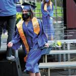 Graduate Mina Cavasos descends the stairs of a stage constructed outside Homer High School to have her picture taken after collecting her diploma during the schools drive-through commencement ceremony Monday, May 18, 2020 at the school in Homer, Alaska. (Photo by Megan Pacer/Homer News)