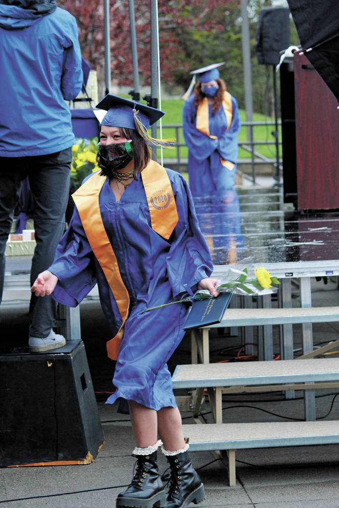 Graduate Mina Cavasos descends the stairs of a stage constructed outside Homer High School to have her picture taken after collecting her diploma during the schools drive-through commencement ceremony Monday, May 18, 2020 at the school in Homer, Alaska. (Photo by Megan Pacer/Homer News)