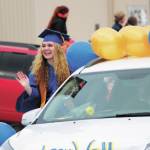 Homer High School graduate Audrey Wallace waves to onlookers while participating in a procession through town with the class of 2020 following their commencement ceremony Monday, May 18, 2020 in Homer, Alaska. (Photo by Megan Pacer/Homer News)