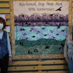 Patrice Krant, left, and Karrie Youngblood, right, pose next to their quilt commemorating the 50th anniversary of Kachemak Bay State Park on Saturday, May 16, 2020, at Grace Ridge Brewery in Homer, Alaska. Krant designed and sewed the quilt and Youngblood did the quilting. Rick Rosebbloom and Krant donated materials and funded the quilt. The back of the quilt has a map of Kachemak Bay State Park. The quilt also features text listing 50 things to do in the park. The quilt was unveiled last Saturday along with the introduction of a special Grace Ridge 50th Anniversary beer. (Photo by Michael Armstrong/Homer News)