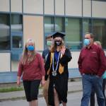 Photos by Brian Mazurek/Peninsula Clarion                                Graduate and valedictorian Katherine Stoll walks with her family to receive her diploma during the Connections Homeschool Class of 2020 graduation at Soldotna Elementary School in Soldotn on May 21.