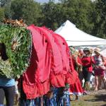 Participants in an aerial art installation march through the Kenai Peninsula Fairgrounds, with a king salmon leading the way, at Salmonfest on Saturday, Aug. 4, 2018 in Ninilchik, Alaska. (Photo by Megan Pacer/Homer News)
