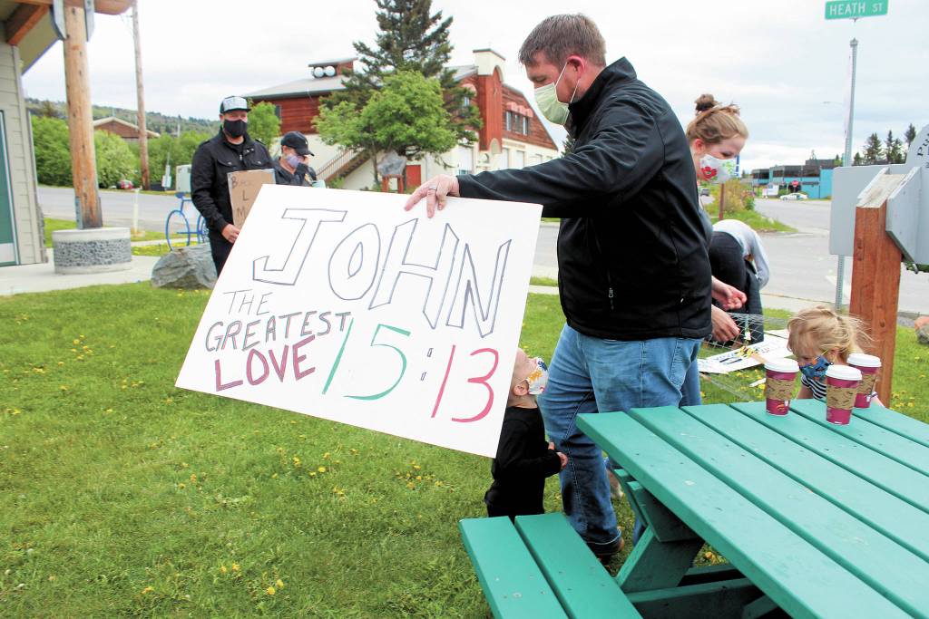 A participant in a Black Lives Matter demonstration Tuesday, June 2, 2020 at WKFL Park in Homer, Alaska holds a sign referring to John 15:13, which reads Greater love has no one than this: to lay down ones life for ones friends. (Photo by Megan Pacer/Homer News)