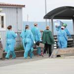 Staff from South Peninsula Hospital and Homer Public Health prepare to board the M/V Tustumena to test 35 crew and six passengers after it docked at the Homer Ferry Terminal on Monday, June 8, 2020 in Homer, Alaska. The ship carried one crew member who tested positive for COVID-19 on Saturday in Dutch Harbor. Health workers tested people on board the ship when it arrived, and crew and passengers were only allowed to disembark if they had private transportation to their final quarantine destination. (Photo by Megan Pacer/Homer News)