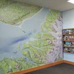 A detailed map of Kachemak Bay State Park, designed by Brentwood Higman, adorns the wall of the Homer Chamber of Commerce & Visitor Center during a celebration of the parks 50th anniversary Saturday, June 6, 2020 in Homer, Alaska. (Photo by Megan Pacer/Homer News)