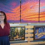 Lydia Johnston stands in front of several of her paintings at a First Friday opening reception on June 5, 2020, at Grace Ridge Brewery in Homer, Alaska. (Photo by Michael Armstrong/Homer News)