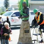 Mike Kennedy, left, Leo Vait, center, and Wayne Aderhold, right, strap the Brother Asaiah statue on a trailer after it was moved from the deck of Cosmic Kitchen on Saturday, June 6, 2020, in Homer, Alaska. Vait created the statue as a commission by John Nazarian, a friend of Asaiah Bates. Nazarian had loaned to the Pioneer Avenue restaurant the statue of the man who coined the phrase Cosmic Hamlet by the Sea to describe Homer. The statue was moved after Cosmic Kitchen owners Michelle Wilson and Sean Hogan sold their restaurant. Cosmic Kitchen closed on Saturday. The Asaiah statue will be stored until a new location can be found. (Photo by Michael Armstrong/Homer News)