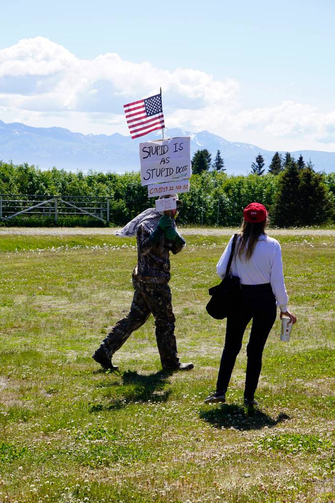 Wearing a respirator, Greg Sutter carries a sign at a campaign rally and ice cream social for Rep. Sarah Vance, R-Homer, on Sunday, June 14, 2020, at Karen Hornaday Park in Homer, Alaska. The sign reads Stupid is as stupid does - Forrest Gump; COVID-19 is no B.S., and Jesus loves you. Sutter was the lone protester at Vances event. (Photo by Michael Armstrong/Homer News)