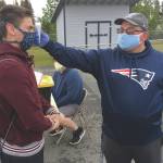 Soldotna assistant football coach Eric Pomerleau checks the temperature of sophomore Joseph Whittom before summer workouts Wednesday, June 17, 2020, at Soldotna High School in Soldotna, Alaska. (Photo by Jeff Helminiak/Peninsula Clarion)