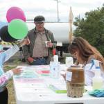 Bumppo Bremicker, center, learns about educational resources at a table at the first ever Juneteenth celebration in Homer, held Friday, June 19, 2020 at WKFL Park in Homer, Alaska. (Photo by Megan Pacer/Homer News)