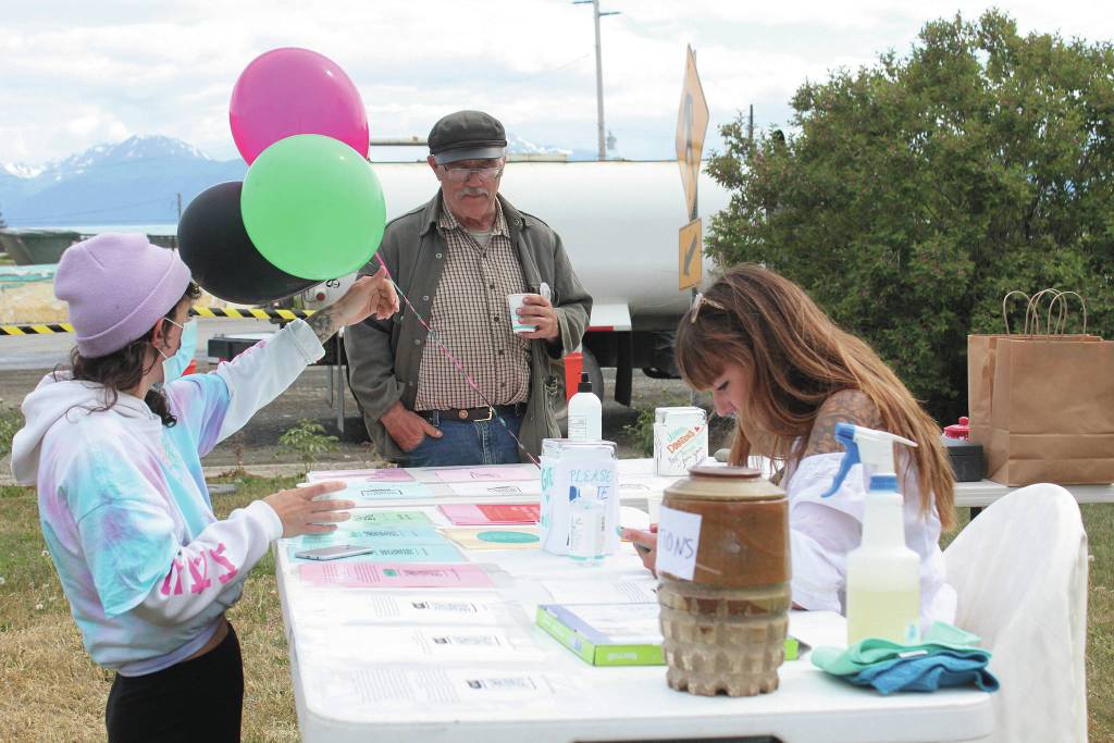 Bumppo Bremicker, center, learns about educational resources at a table at the first ever Juneteenth celebration in Homer, held Friday, June 19, 2020 at WKFL Park in Homer, Alaska. (Photo by Megan Pacer/Homer News)