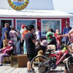 Visitors enjoy the sun on July 4, 2020, on a deck at a Homer Spit boardwalk in Homer, Alaska. In a press conference on Tuesday, July 7, 2020, Alaska Chief Medical Officer Dr. Anne Zink advised people to minimize the risk of getting infected by COVID-19 by avoiding crowded spaces. (Photo by Michael Armstrong/Homer News)