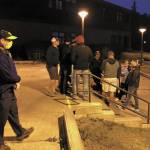 Homer High School Principal Douglas Waclawski (left) stands at the entrance to the local high school while residents show up in search of higher ground in the early morning hours of Wednesday, July 22, 2020 in Homer, Alaska. Homer High School is the designated evacuation location for those below the inundation zone with nowhere else to evacuate to during a tsunami warning. (Photo by Megan Pacer/Homer News)