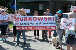 In this June 2019 photo, people gather outside U.S. Sen. Lisa Murkowskis office in Juneau, Alaska, to protest the proposed Pebble Mine. The Pebble Limited Partnership, which wants to build a copper and gold mine near the headwaters of a major U.S. salmon fishery in southwest Alaska, says it plans to offer residents in the region a dividend. (AP Photo/Becky Bohrer, File)