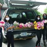 Homer High School students working on a service project hold some of the peonies they delivered on Tuesday, Aug. 4, 2020, to 150 Homer, Alaska, area businesses, nonprofits and institutions  organizations with frontline employees working during the COVID-19 pandemic. Places receiving peonies included South Peninsula Hospital, Long Term Care, the Homer Senior Center and South Peninsula Haven House. The peonies were donated by Alaska Perfect Peonies by owner Rita Jo Shoultz and were left over from this years crop of the decorative flower. From left to right are Gideon McGhee, Angelia McGhee, Sameah McGhee and Lucinda Maryott. (Photo by Michael Armstrong/Homer News)