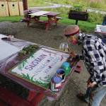 Debi Poore paints a sign at Land Acknowledgement in Action: Sign Installation last Saturday, Aug. 22, 2020, at the Bishops Beach pavillion  the area known by the Denaina people as Tuggeht, or at the waters edge. (Photo by Michael Armstrong/Homer News.
