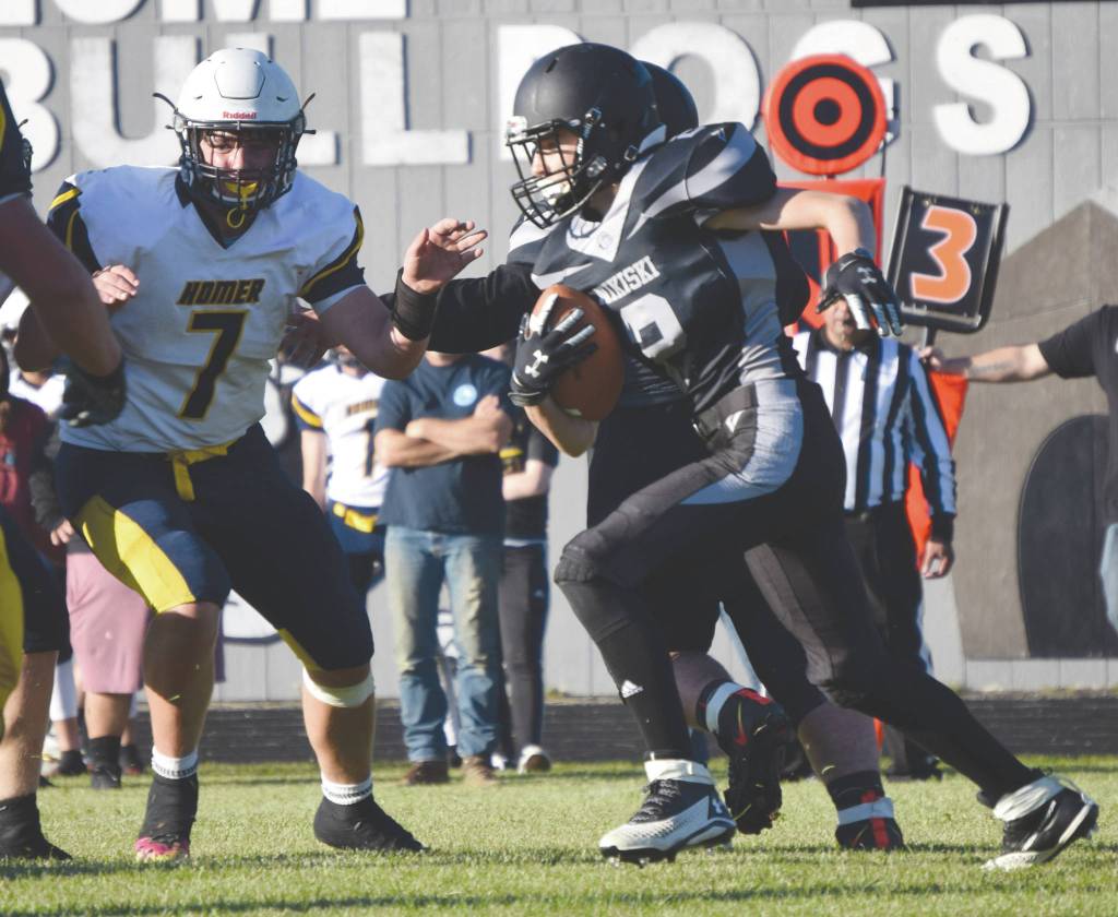 Nikiskis Holden Warnke rushes past Homers Carter Tennison on Friday, Sept. 11, 2020, at Nikiski High School in Nikiski, Alaska. (Photo by Jeff Helminiak/Peninsula Clarion)