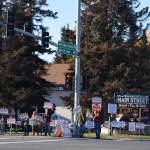 People hold signs at the intersection of Main Street Loop and Kenai Spur Highway on Tuesday, Oct. 6, 2020 in Kenai, Alaska. (Photo by Ashlyn OHara/Peninsula Clarion)