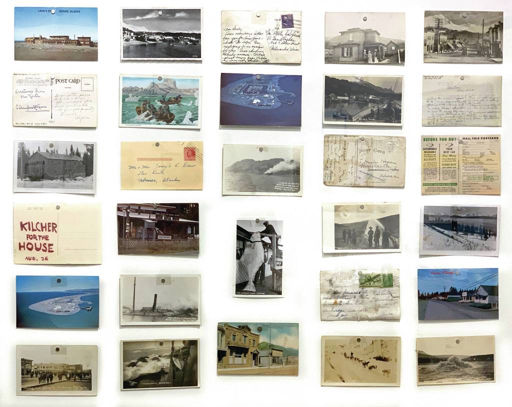 A display from the Pratt Museums Greetings from the Past: History in Postcards shows postcards from the museums collection from Homer and around the state. It includes postcard of Lands End Resort, upper left, several postcards of the Homer Spit, and a campaign postcard for Yule Kilcher when he ran for the Alaska House of Representatives. The exhibit opened Thursday, Oct. 22, 2020, at the Pratt Museum in Homer, Alaska. (Photo courtesy Pratt Museum)