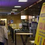 Passengers at the Juneau International Airport make their way past signage notifying the public about the state's travel restrictions on Monday, Nov. 15, 2020. Gov. Mike Dunleavy issued a new emergency declaration which took effect Monday, which outlined a number of travel guidelines for both in-state and out-of-state travel. (Peter Segall / Juneau Empire)