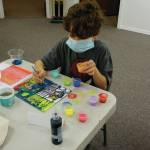 Ryder Chase, age 9, works on faux stained glass in Amy Komars socially-distant Art a la Carte class last Friday at the Homer Council on the Arts. Children in the class wore masks and worked at either end of long tables spaced apart. The young artists also made large origami stars that will be placed in store windows for a dose of color therapy for the community, Komar said. (Photo by Michael Armstrong/Homer News)
