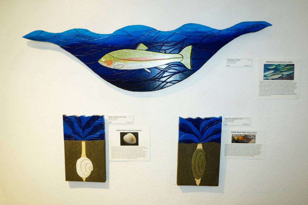 Steelhead in a Stream, top, Butter Clam Burrowed in Sand, lower left, and Razor Clam Burrowed in Sand, lower right, are three of the pieces in Kim Schusters exhibit, Science Observed Through Art: Unsung Species, as seen here on Friday, Dec. 4, 2020, at Ptarmigan Arts in Homer, Alaska. (Photo by Michael Armstrong/Homer News)