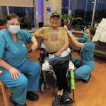 Larry Young, a resident of South Peninsula Hospitals Long Term Care wing, is the first resident to be inoculated with a dose of the Pfizer COVID-19 vaccine on Thursday, Dec. 17, 2020 at the nursing home in Homer, Alaska. Administering his shot is nurse practitioner Rachael Kincaid (right), while Long Term Care Medical Director Teresa Johnson, MD, stands by (left). (Photo courtesy Derotha Ferraro/South Peninsula Hospital)