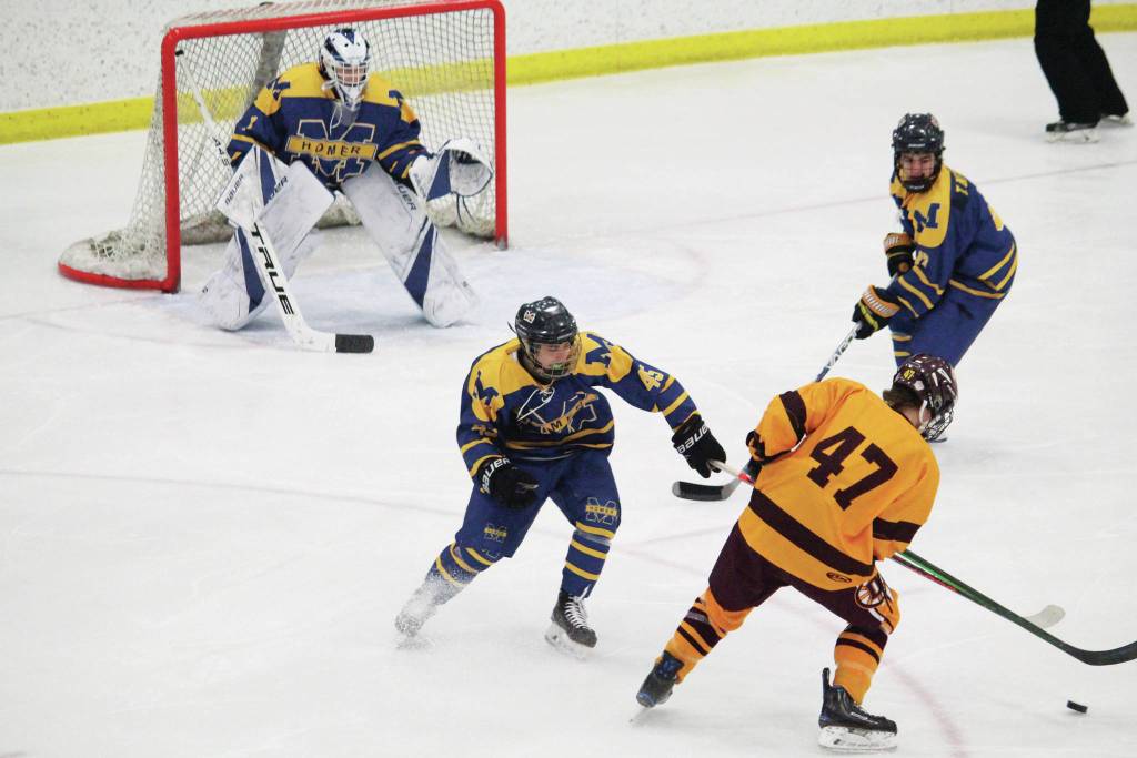 Homers Bergen Knutson (left) and Toby Nevak (right) try to fend off Dimonds Kaden Daniels during a Friday, Feb. 14, 2020 game at the 2020 ASAA First National Cup Division I Hockey State Championship at the Curtis D. Menard Memorial Sports Center in Wasilla, Alaska. (Photo by Megan Pacer/Homer News)
