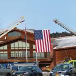 An American flag is suspended between two ladder trucks outside Homer High School for the memorial for Gary Thomas, a Homer man who was killed in a water heater explosion this month, on Sunday, Jan. 19, 2020 in Homer, Alaska. Thomas was a volunteer firefighter for more than 40 years. (Photo by Megan Pacer/Homer News)