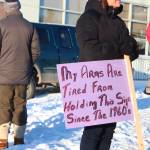 A woman holds a sign that reads My arms are tired from holding this sign since the 1960s beforfe the fourth Womens March on Homer on Saturday, Jan. 18, 2020 in Homer, Alaska. About 300 community members gathered outside the Homer Education and Recreation Complex before marching down Pioneer Avenue to WKFL Park. (Photo by Megan Pacer/Homer News)