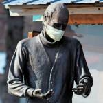The statue of Brother Asaiah Bates that stands at Cosmic Kitchen is seen wearing a mask on Monday, April 6, 2020 in Homer, Alaska. The state of Alaska is currently advising people to wear protective cloth coverings when they have to go out in public for essentials. (Photo by Megan Pacer/Homer News)