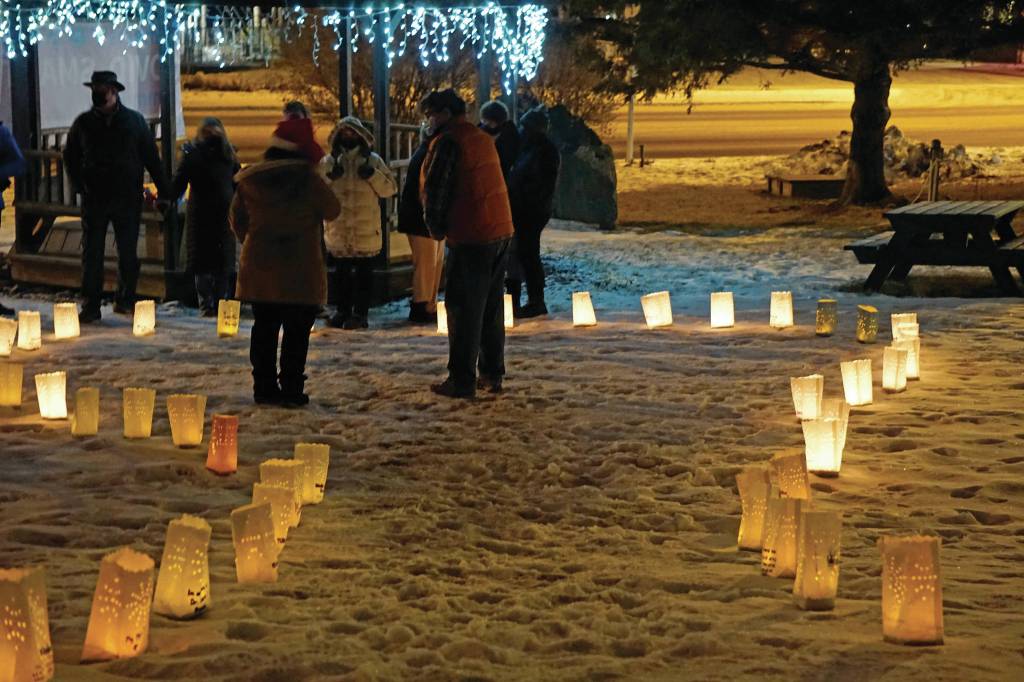 Memorial luminarias provide a somber light at Hospice of Homers Light Up a Life and 35th Anniversary Gathering last Friday, Dec. 18, 2020, at WKFL Park in Homer, Alaska. The event honored staff and volunteers who have helped out at the organization over the decades. As a fundraiser for hospice, people purchased luminarias to honor deceased friends and family. Luminarias are a Hispanic tradition where candles are placed in a paper bag weighed down with sand. Also known as farolitios, Catholics place luminarias to guide the spirit of the Christ child to ones home. (Photo by Michael Armstrong/Homer News)