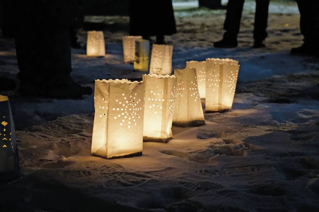 Memorial luminarias provide a somber light at Hospice of Homers Light Up a Life and 35th Anniversary Gathering last Friday, Dec. 18, 2020, at WKFL Park in Homer, Alaska. The event honored staff and volunteers who have helped out at the organization over the decades. As a fundraiser for hospice, people purchased luminarias to honor deceased friends and family. Luminarias are a Hispanic tradition where candles are placed in a paper bag weighed down with sand. Also known as farolitios, Catholics place luminarias to guide the spirit of the Christ child to ones home. (Photo by Michael Armstrong/Homer News)