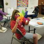 Dee Wilmeth, age 9, shows an origami star she made in Amy Komars socially-distant Art a la Carte class on Friday, Nov. 20, 2020, at the Homer Council on the Arts. Children in the class wore masks and worked at either end of long tables spaced apart. The stars will be placed in store windows for a dose of color therapy for the community, Komar said. (Photo by Michael Armstrong/Homer News)