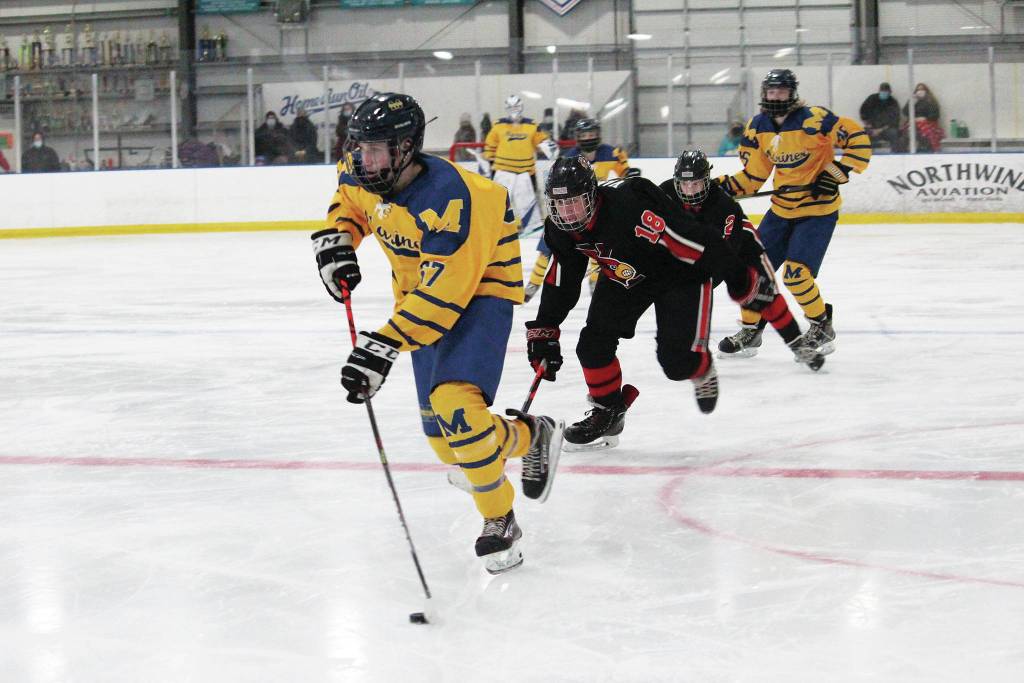 Homers Matfey Reutov takes the puck into Kardinal territory with Kenai players in pursuit during a Friday. Jan. 22, 2021 hockey game at Kevin Bell Arena in Homer, Alaska. (Photo by Megan Pacer/Homer News)