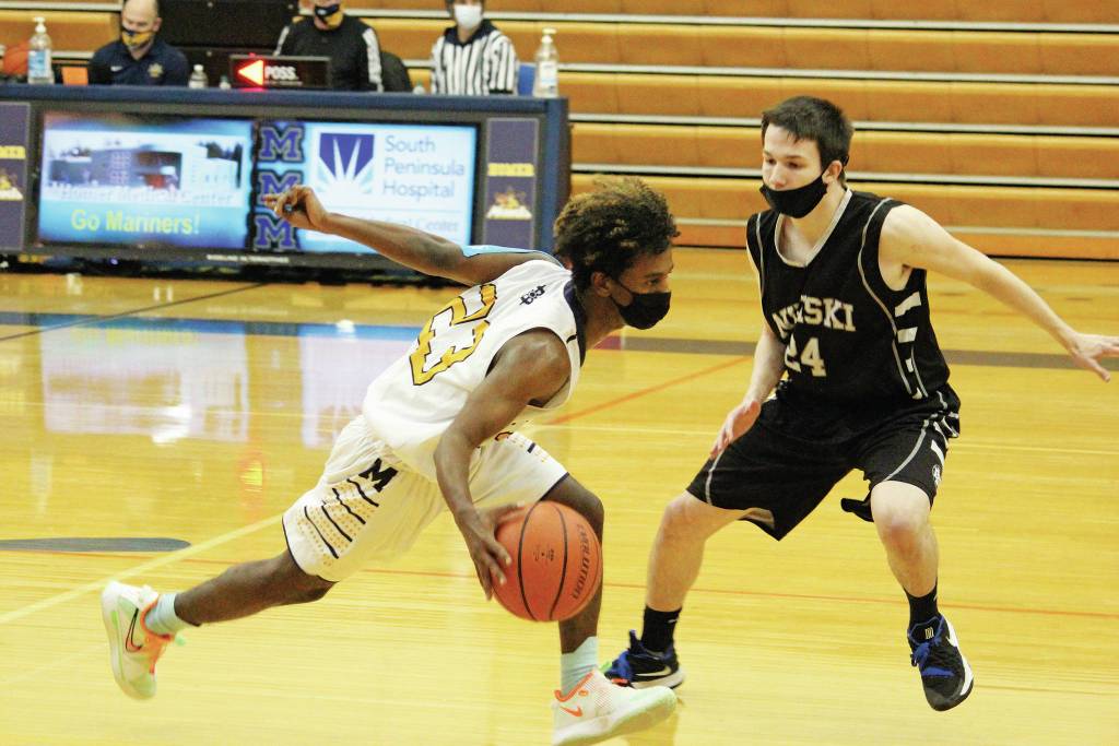 Homers Eyoab Knapp takes the ball down the court under pressure from Nikiskis Kyle Malston during a Tuesday, Feb. 2, 2021 basketball game at the Alice Witte Gymnasium in Homer, Alaska. (Photo by Megan Pacer/Homer News)