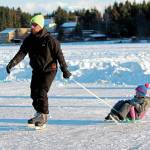 Phil Basargin 5-year-old Maxim Basargin around the ice Saturday, Feb. 6, 2021 during the Skate the Lake event on Beluga Lake in Homer, Alaska. The free skating event was hosted for the community by the Homer Hockey Association. (Photo by Megan Pacer/Homer News)