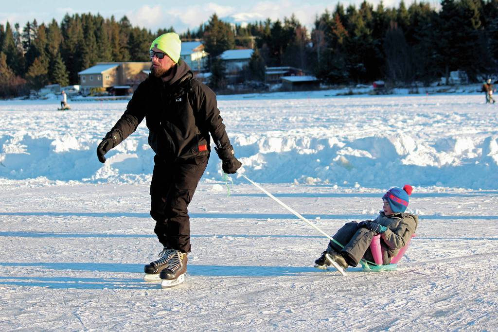 Phil Basargin 5-year-old Maxim Basargin around the ice Saturday, Feb. 6, 2021 during the Skate the Lake event on Beluga Lake in Homer, Alaska. The free skating event was hosted for the community by the Homer Hockey Association. (Photo by Megan Pacer/Homer News)