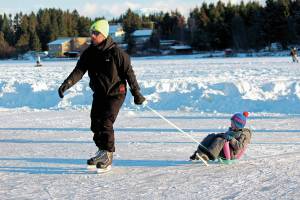 Phil Basargin 5-year-old Maxim Basargin around the ice Saturday, Feb. 6, 2021 during the Skate the Lake event on Beluga Lake in Homer, Alaska. The free skating event was hosted for the community by the Homer Hockey Association. (Photo by Megan Pacer/Homer News)