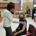 Tracy Silta (left) administers a dose of a COVID-19 vaccine to Melissa Linton during a vaccine clinic at Soldotna Prep School on Friday, Feb. 26, 2021 in Soldotna, Alaska. (Photo by Ashlyn OHara/Peninsula Clarion)