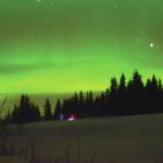 Sue Post and Jim Levine walk across a field to observe northern lights on Tuesday, March 2, 2021, in Diamond Ridge near Homer, Alaska. (Photo by Michael Armstrong/Homer News)