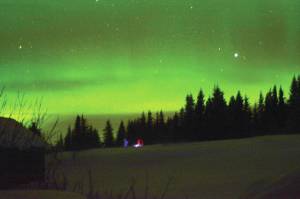 Sue Post and Jim Levine walk across a field to observe northern lights on Tuesday, March 2, 2021, in Diamond Ridge near Homer, Alaska. (Photo by Michael Armstrong/Homer News)